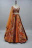 Rust lehenga with rich velvet panels, intricate embroidery, and mirror detailing.
