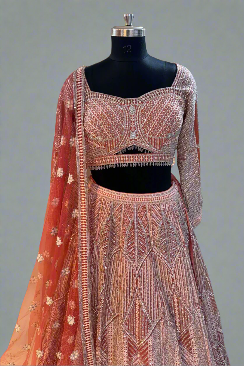 Grace your occasion in this peach-pink shimmer lehenga with intricate geometric sequin and bead embroidery