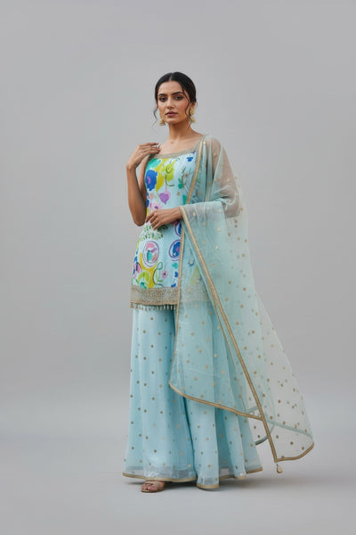 Elegant beige palazzo suit with vibrant floral top and subtle gold accents