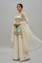 Elegant beige palazzo suit with vibrant floral top and subtle gold accents
